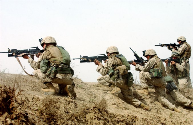 U.S. marines fire on a group of insurgents shortly after they launched a rocket propelled grenade at their 7-ton truck while on a 'movement-to-contact mission in order to flush out insurgents operating in the Fallujah area  south of Fallujah on Thursday, April 15, 2004 in Iraq.  The marines are part of the 3rd Battalion, 4th marine regiment, which saw heavy combat at the beginning of the war last year, and is now back in Iraq embroiled in intense fighting with the resistance.  Today, the men of the 3rd Battalion were ambushed half a dozen times while they patrolled the palm groves and wheat fields around fallujah, and the marines killed at least 10 insurgents, and suffered only minor injuries. (Credit: Lynsey Addario/ Corbis, for The New York Times)